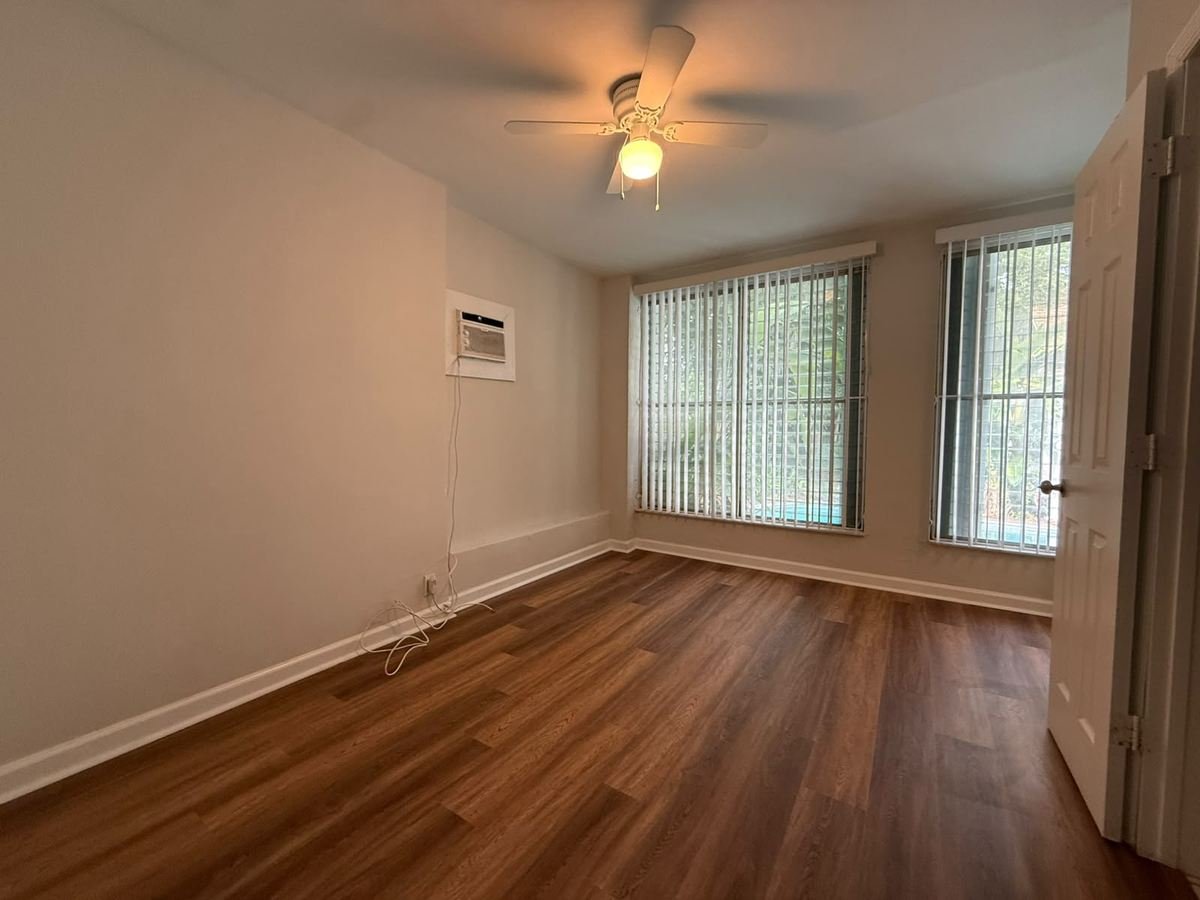 The same bedroom with new vinyl plank flooring and freshly painted warm walls