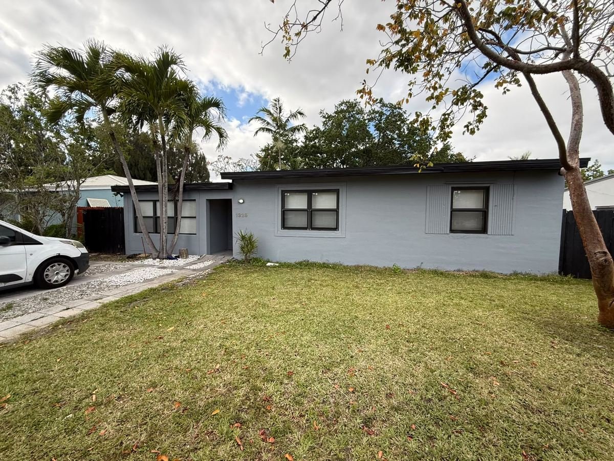 The same home after a full exterior repaint in modern grey with dark trim