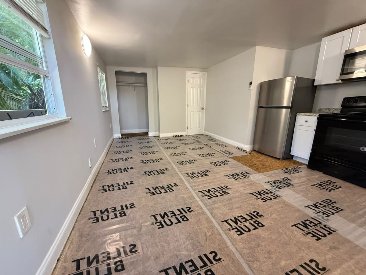 Subfloor with acoustic underlayment laid out before vinyl plank installation